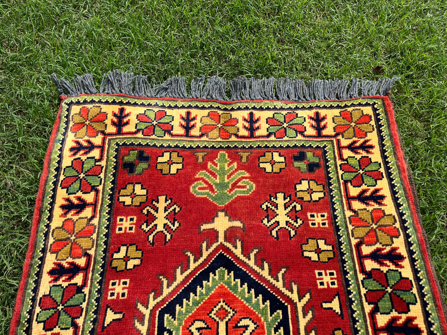 Decorative rug with intricate patterns on a grassy background
